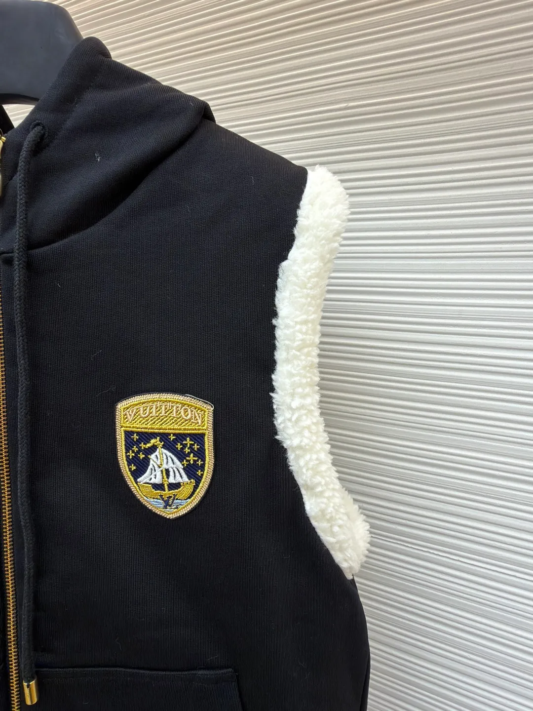 LOUIS VUITTON embroidered reversible hooded vest ●Original version: purchased and developed by 14599 ●Item number: 1681399-C00 ●Fabric: lamb wool fabric ●Technology: embroidery production ●Color: black/white ●Version: fitted version ●Weight: about 1040 grams ●Size: S-M-L-XL ●Description: This vest adopts a double-sided design. One side is made of high-quality knitted fabric, which is crisp, stylish, skin-friendly and comfortable; the other side is made of imitation lamb wool, which is fluffy, soft and has good warmth retention. The hooded part is made of knitted fabric of the same color and is equipped with a two-way zipper with a metal zipper puller, which is smooth and durable. The flip design of cotton knitted surface and comfortable suede surface is very ingenious. It uses advanced double-sided weaving and composite technology to perfectly integrate the two materials and make the transition natural when switching; the shield logo patch uses high-precision patching technology, with neat edges and clear and three-dimensional patterns; the embroidered logo on the back uses fine embroidery technology, with fine and even stitches, and the logo is perfectly integrated into the back design; the drawstring hood uses high-quality drawstrings and precision sewing technology, which not only ensures the adjustment function of the hood, but also enhances the overall sense of leisure. The overall wiring is straight and delicate, the fabric is comfortable and soft, and the color is consistent without color difference. It can be matched with the same style to create a fashionable look and control various occasions. Customized accessories, complete with three standards, same style for men and women!
